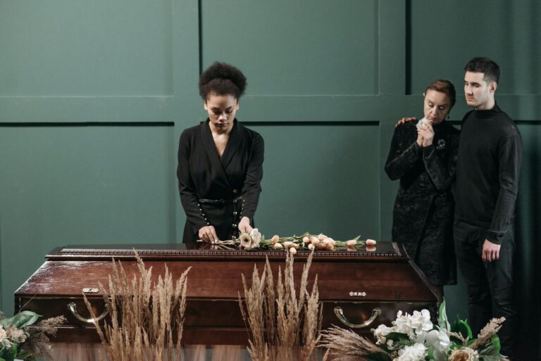 A heartfelt funeral scene indoors featuring grieving adults and a coffin adorned with flowers.