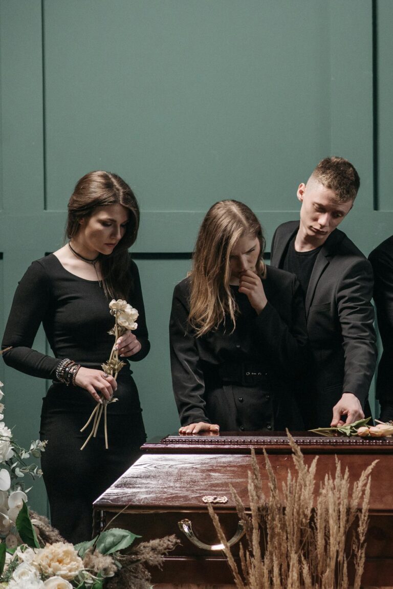 A somber gathering of people in black clothing at a funeral, conveying grief and solidarity.